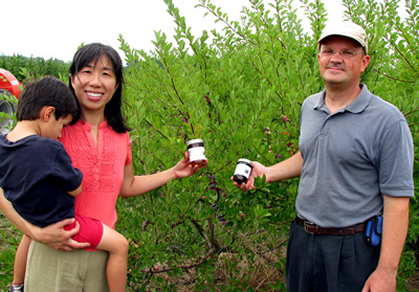 Drs. Richard and Wenfei Uva holding beach plums produced on their farm